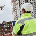 Drone operated by construction worker on building site