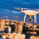 drone with digital camera flying at city street