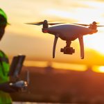 Operator inspecting construction building site using drone