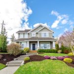 Luxury house with beautiful landscaping on a sunny day.